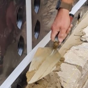 Bricklayer constructing a stone wall